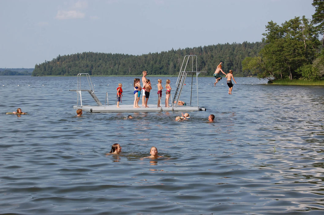 Personer som står i kö för att hoppa från en EasyFloat badflotte med hopptorn i två höjder