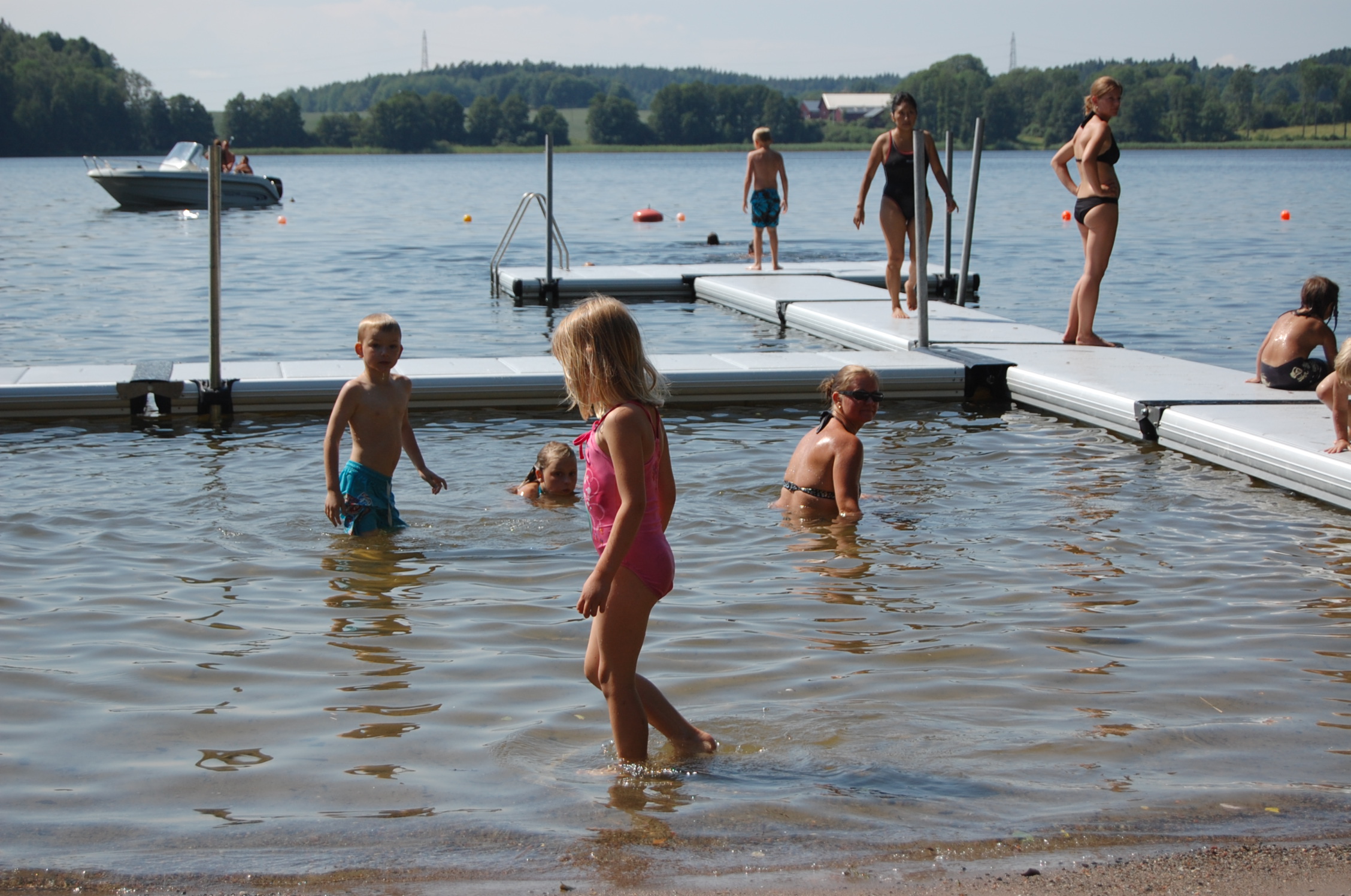 Barn och vuxna badar vid en offentlig EasyFloat flytbrygga på Stendalsbadet under sommaren